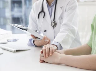 врач держит за руку пациента